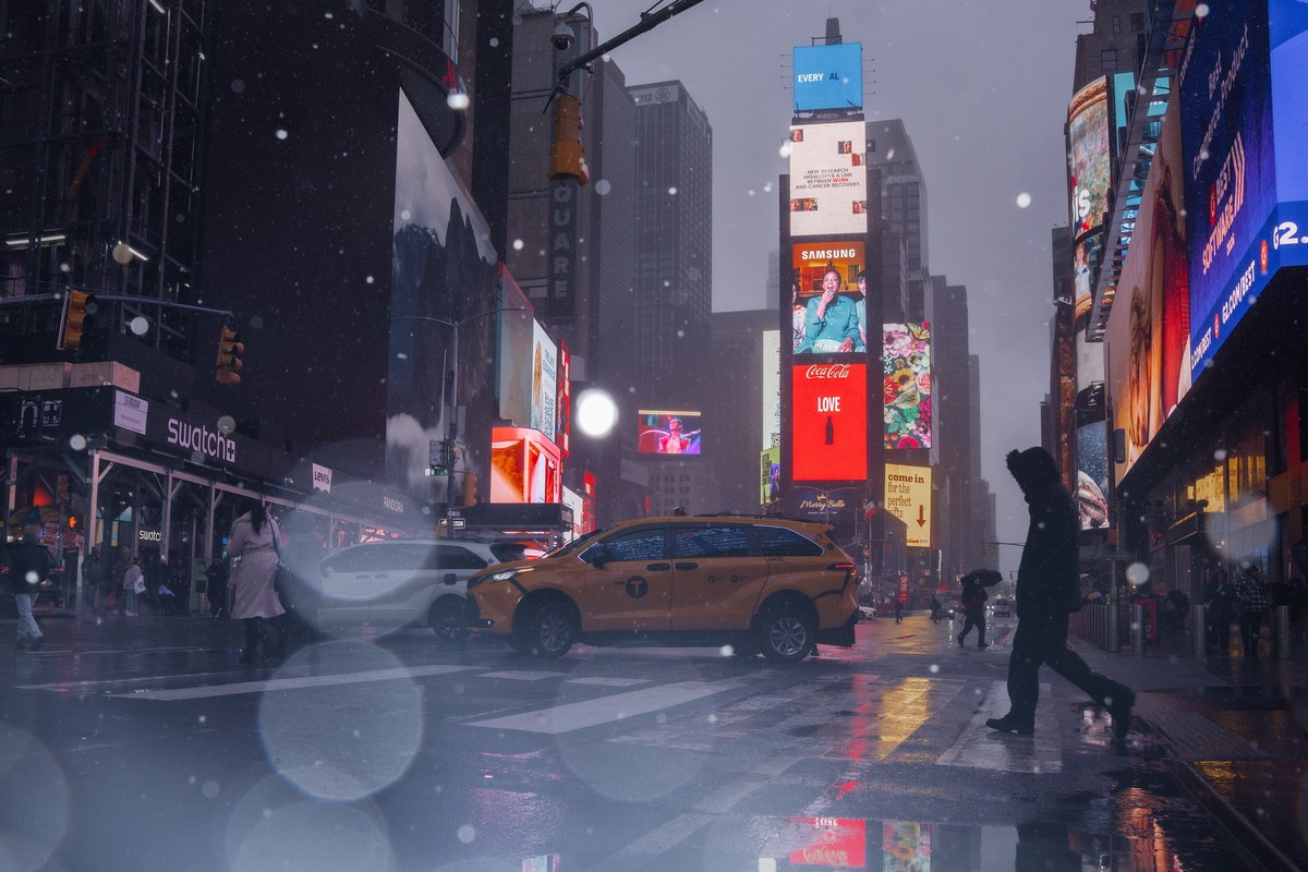 epa12770156 People walk in Times Square as a winter blizzard is expected to begin in New York, New York, USA, 22 February 2026. The National Weather Service has issued a blizzard warning for New York  ...