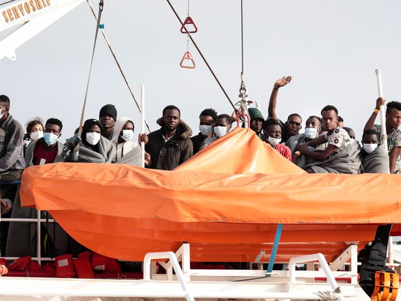 epa09540800 Migrants on board the ship Sea-Watch 3 arrive in Pozzallo, near Ragusa, Sicily Island, southern Italy, 23 October 2021. The Sea Watch 3 ship arrived in Pozzallo with 406 migrants rescued i ...