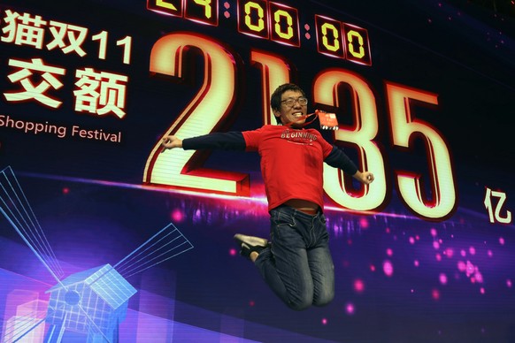 A staff member jumps for a photo to celebrate after Alibaba&#039;s 11.11 Global Shopping Festival also known as Singles Day sets a new record of RMB213.5 billion or more than US$30 billion in Shanghai ...