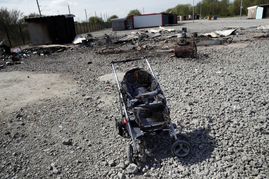 A partially burned push chair abandonned by migrants is pictured in a camp in the Dunkirk suburb of Grande-Synthe, northern France, Tuesday, April 11, 2017. Several hundred migrants have disappeared a ...