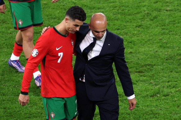 epa11461219 Spanish head coach Roberto Martinez of Portugal (L) interacts with Cristiano Ronaldo of Portugal after losing the UEFA EURO 2024 quarter-finals soccer match between France and Portugal, in ...
