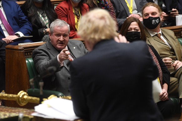 epa09629856 A handout photograph released by the UK Parliament shows Ian Blackford (L), leader of the Scottish National Party (SNP) in the House of Commons, addressing British Prime Minister Boris Joh ...