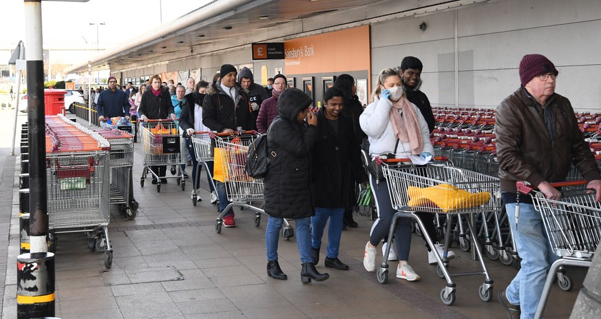 epa08313273 Shoppers queue outside a supermarket in south London, Britain, 22 March 2020. Pensioners and vulnerable people has been struggling to buy their essential shopping due to unprecedented dema ...
