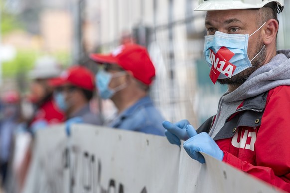 Des personnes portant des masques faciaux de protection manifestent lors dÃune action du syndicat Unia contre lÃinterdiction des syndicats dÃacceder aux chantiers pour controler les normes de lÃOF ...