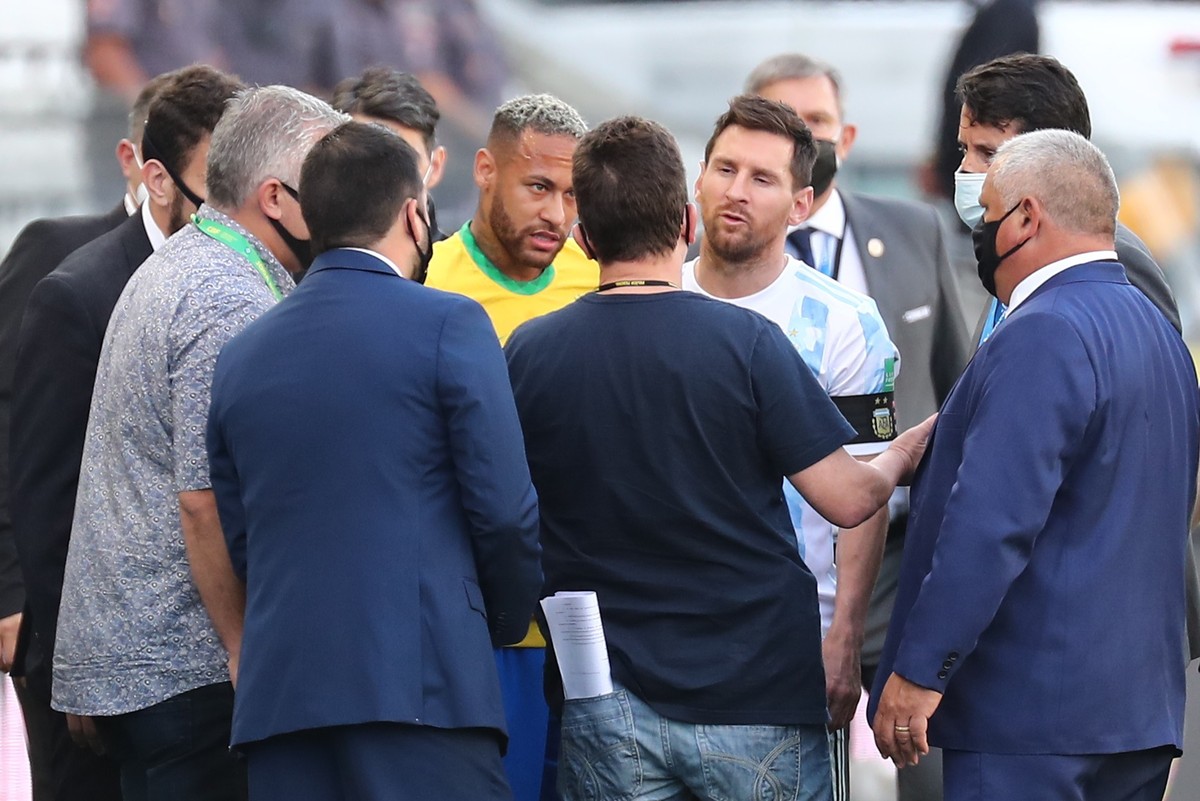 epa09450172 Brazil's Neymar Jr (C-L) and Argentina's Lionel Messi (C-R) speak with Brazilian health officials after they stopped the South American qualifier soccer match for the Qatar 2022  ...