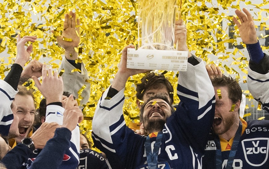Die Zuger mit Captain Raphael Diaz, Mitte, stemmen den Meisterpokal und feiern als Eishockey Schweizermeister nach dem dritten Eishockey Playoff-Finalspiel der National League zwischen dem EV Zug und  ...