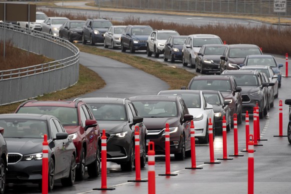 epaselect epa09660742 A long line of vehicles wait at a Covid-19 drive-thru testing event in Leesburg, Virginia, USA, 30 December 2021. The Loudoun County government held a free drive-thru Covid-19 te ...