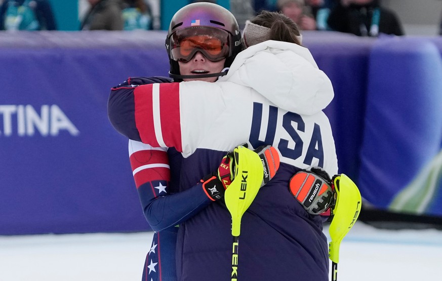 United States' Mikaela Shiffrin, left, is hugged by her teammate United States' Breezy Johnson at the finish area of an alpine ski, women's team combined race, at the 2026 Winter Olympi ...