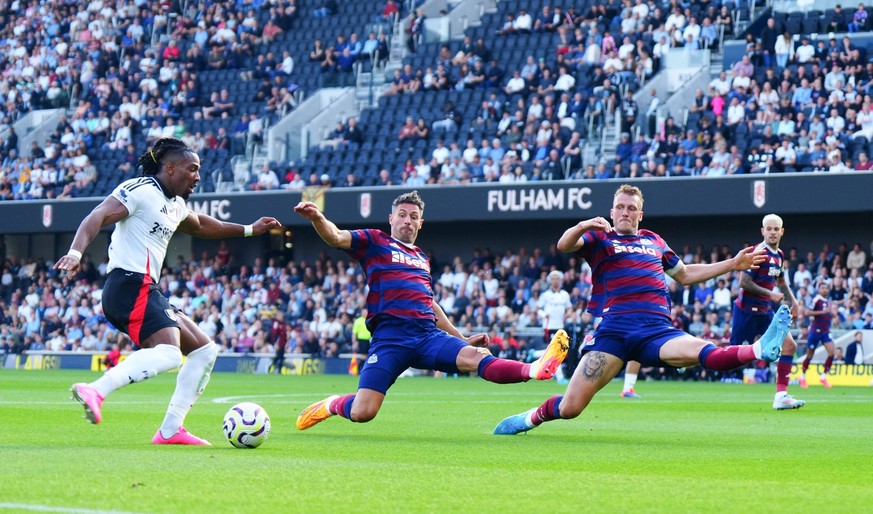 Fabian Schar and Dan Burn of Newcastle United try and stop a cross from Adama Traore of Fulham Fulham v Newcastle United, Premier League, Football, Craven Cottage, London, UK, 21 Sep 2024 EDITORIAL US ...
