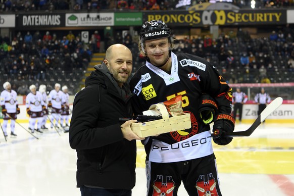 SCB Sportchef Andrew Ebbett, links, uebergibt Berns Calle Andersson, rechts, fuer sein 300. Spiel einen Geschenkskorb, vor dem Eishockey Meisterschaftsspiel der National League zwischen dem SC Bern un ...