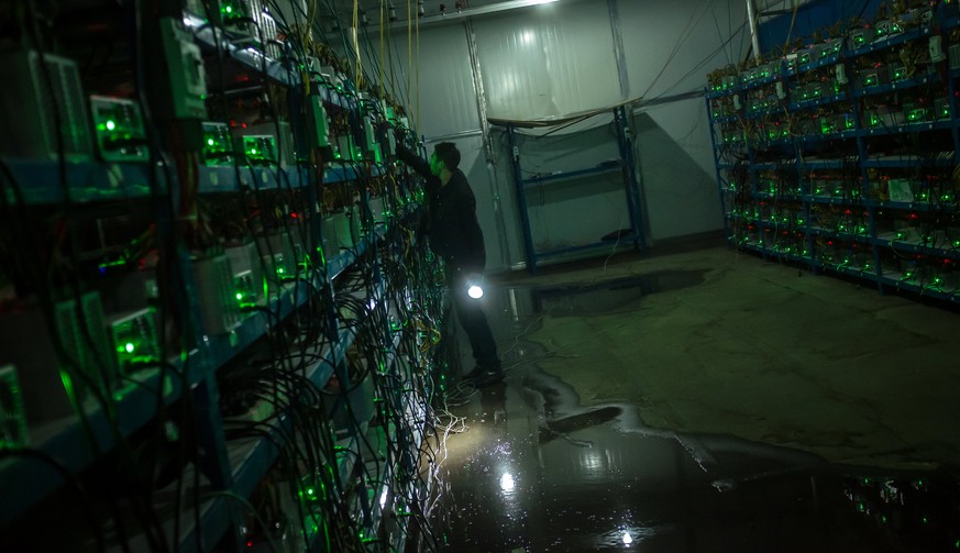 epa06062674 (03/26) Bitcoin miner Huang inspects a malfunctioning mining machine during his night shift at the Bitcoin mine in Sichuan Province, China, 26 September 2016. Miners can check a machine&#0 ...