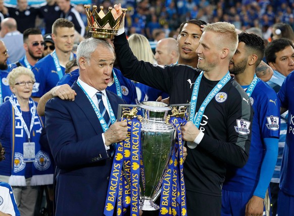 FILE - Leicester City team manager Claudio Ranieri has the crown of the trophy placed on his head by Leicester goalkeeper Kasper Schmeichel as they celebrate becoming the English Premier League soccer ...