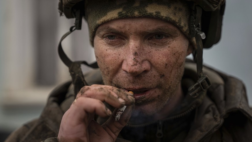 A Ukrainian serviceman aka Iva smokes a cigaret as he just come back from tranches of Bakhmut in Chasiv Yar, Ukraine, Wednesday, March 8, 2023. (AP Photo/Evgeniy Maloletka)
