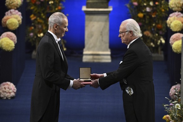 Moungi G. Bawendi, left, is awarded the 2023 Nobel Prize in Chemistry by Sweden&#039;s King Carl Gustaf during the Nobel Prize award ceremony at the Concert Hall in Stockholm, Sweden, Sunday Dec. 10,  ...
