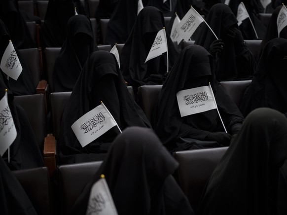 Women wave Taliban flags as they sit inside an auditorium at Kabul University&#039;s education center during a demonstration in support of the Taliban government in Kabul, Afghanistan, Saturday, Sept. ...