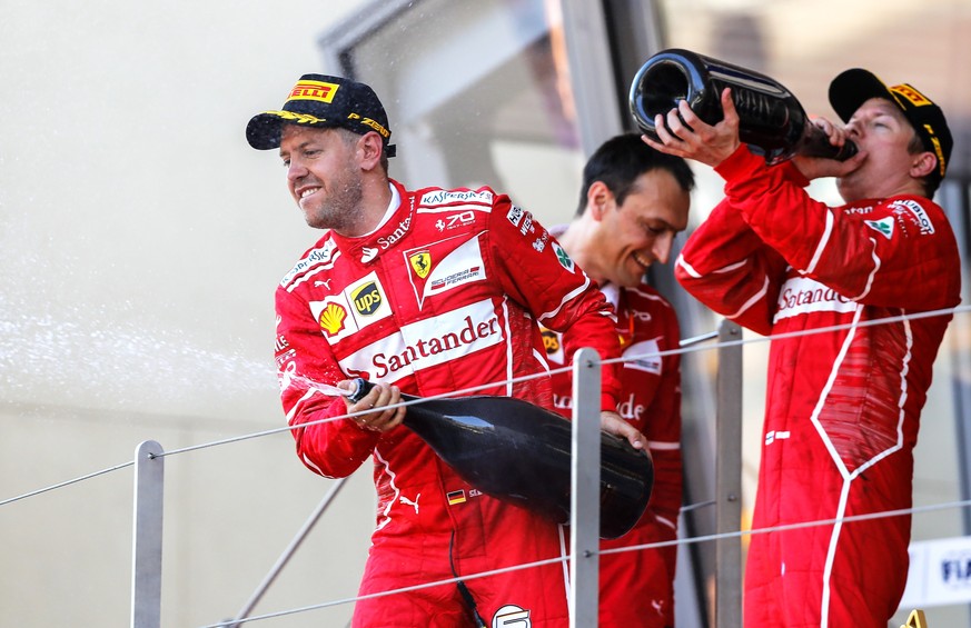 epa05995547 German Formula One driver Sebastian Vettel (L) of Scuderia Ferrari celebrates on the podium next to his second placed Finnish teammate Kimi Raikkonen (R) after winning the Monaco Formula O ...