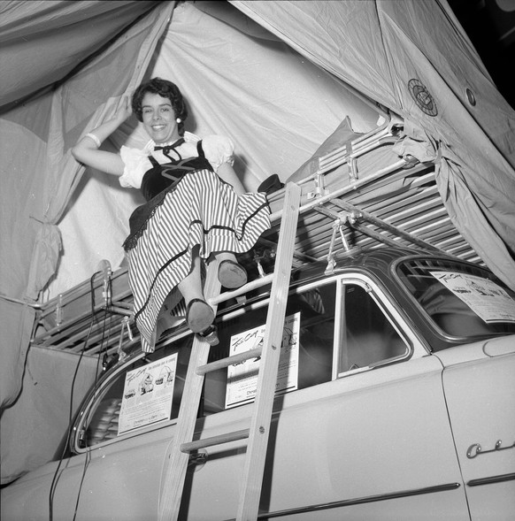 Photographer: Lang, Candide;  Gerber, Hans Title: Geneva Motor Show Description: Woman on car roof Date: 1956 Recorded in: Geneva Motor Show, 1956.