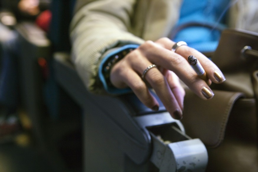 A woman smokes a cigarette in a smoking compartment of a train from Zurich to Winterthur, Switzerland, on November 9, 2005. (KEYSTONE/Martin Ruetschi) 

Eine Frau raucht im Raucherabteil der SBB zwisc ...