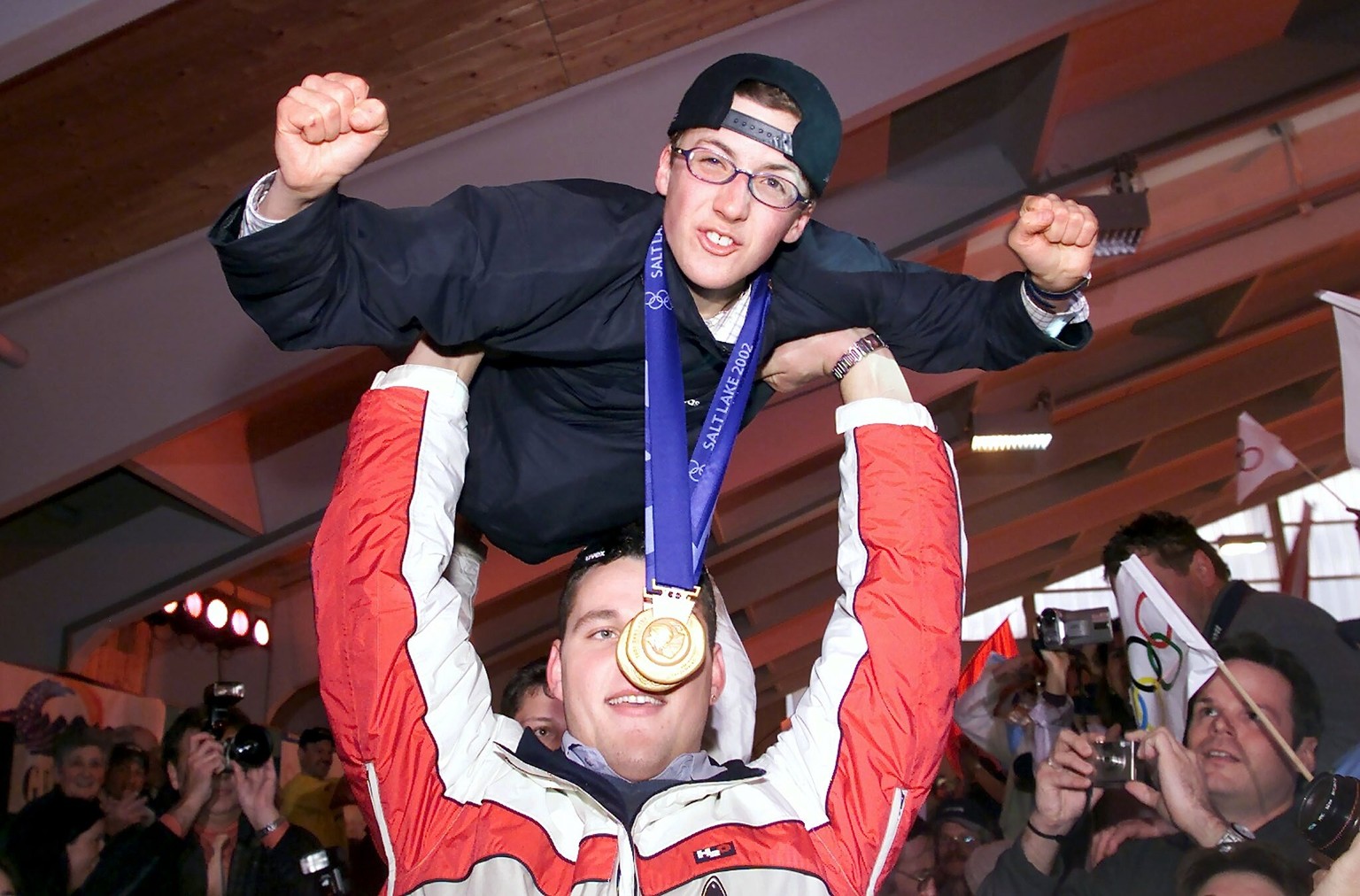 Auf den Haenden der Schwingerkoenige Noeldi Forrer und Joerg Abderhalden, hinten verdeckt, fliegt der Doppelolympiasieger Simon Ammann am Sonntag, 24. Februar 2002 in die Festhalle in Unterwasser ein. ...