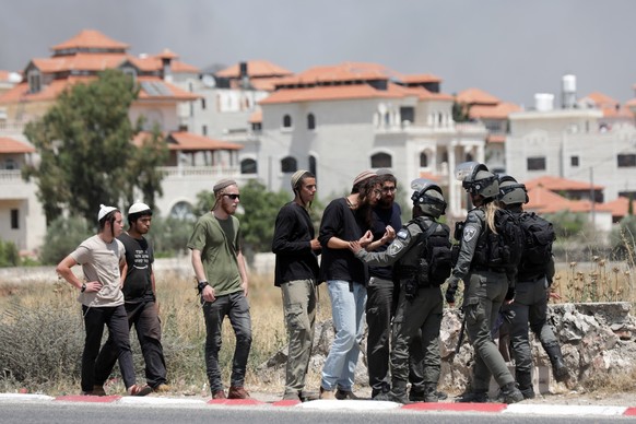 epa10703677 Israeli settlers argue with Israeli border police at the entrance to the Palestinian town of Turmus Aya, next to the Israeli settlement of Eli in the West Bank, June 21, 2023. Four people were…