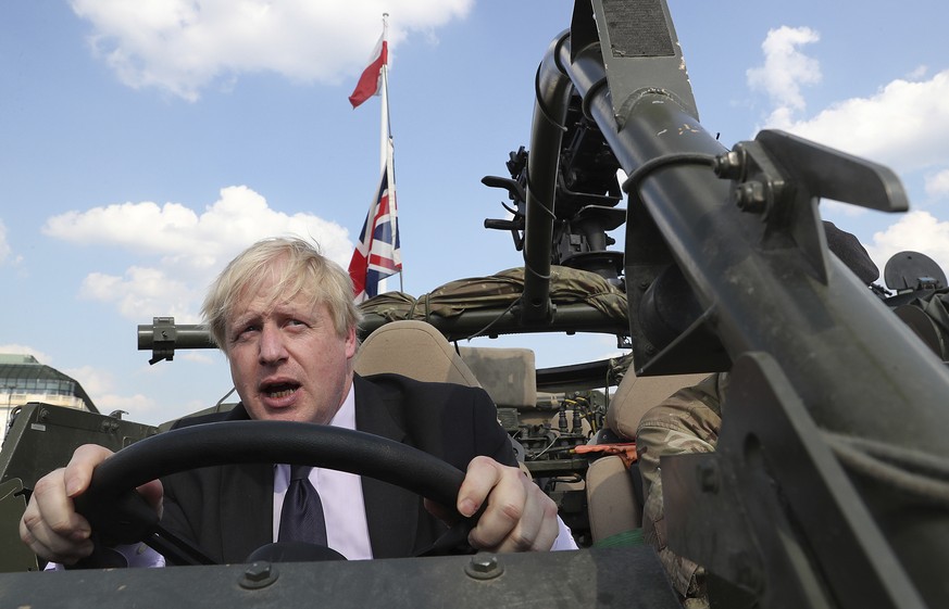 FILE - In this Thursday, June 21, 2018 file photo Britain&#039;s then Foreign Secretary Boris Johnson talks to a British armed forces serviceman based in Orzysz, in northeastern Poland, during a cerem ...