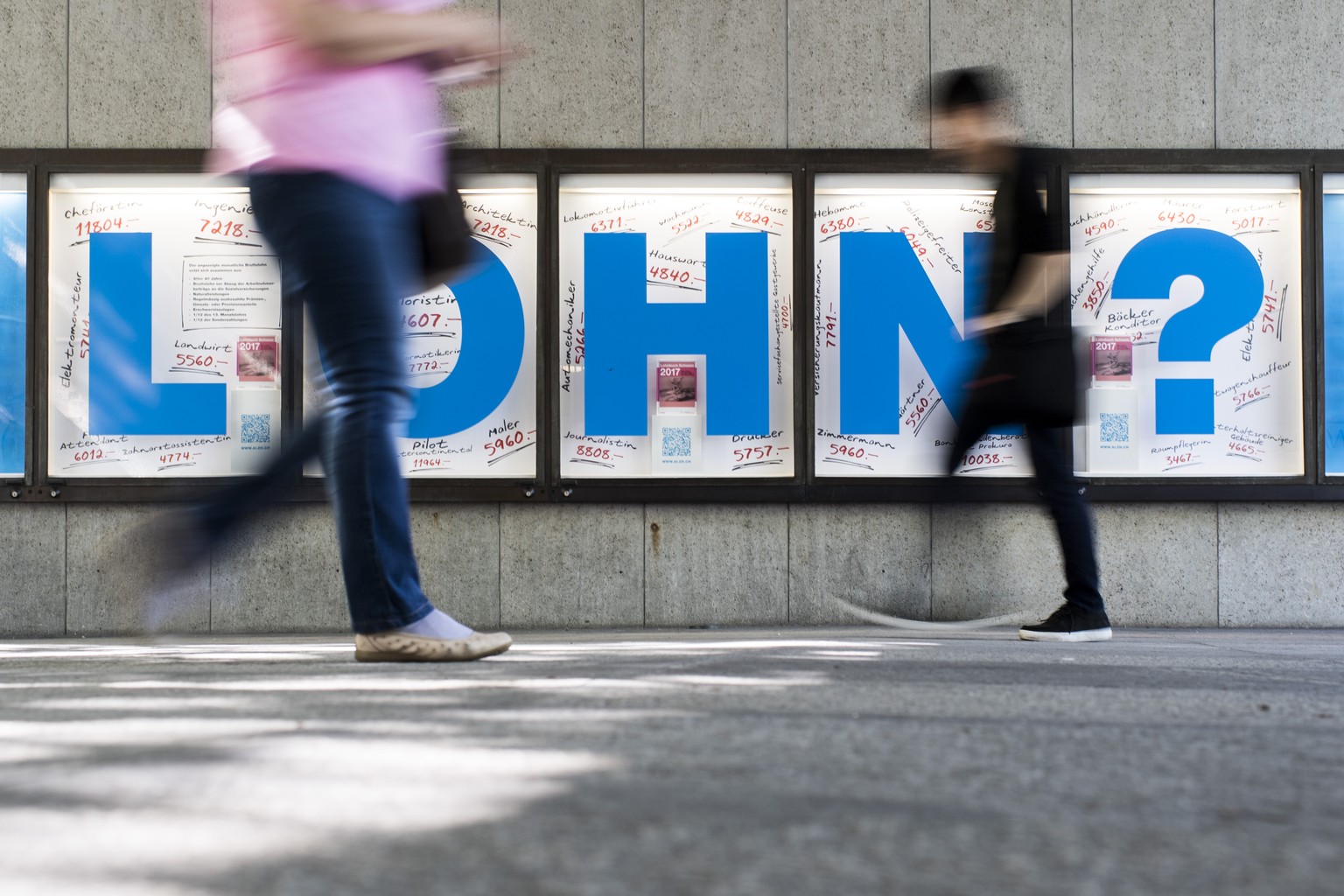 Menschen bewegen sich vor einem Plakat mit der Aufschrift &quot;Lohn?&quot;, aufgenommen am Donnerstag, 6. Juli 2017 in Zuerich. (KEYSTONE/Ennio Leanza)