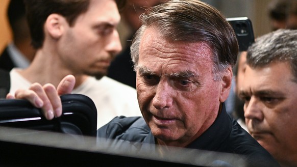 epa12259777 Former Brazilian President Jair Bolsonaro (C), leaves the headquarters of the Liberal Party in Brasilia, Brazil, 24 July 2025. Restrictions on Bolsonaro were ordered as part of a new inves ...