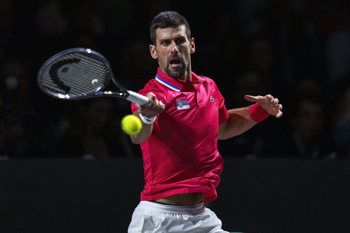 Novak Djokovic of Serbia returns the ball against Jannik Sinner of Italy during a Davis Cup semi-final tennis match between Italy and Serbia in Malaga, Spain, Saturday, Nov. 25, 2023. (AP Photo/Manu F ...