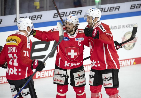 Switzerland&#039;s Andres Ambuehl, center, celebrates his goal with Enzo Corvi, left, and Simon Moser, during their Germany Cup, ice hockey match against Switzerland, in Krefeld, Germany, Sunday, Nov. ...