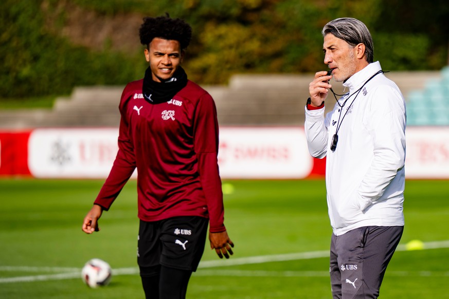 Switzerland's head coach Murat Yakin, right, holds a whistle as he talks to players during a training session of Switzerland's national soccer team in Lausanne, Switzerland, Wednesday, Nov.  ...
