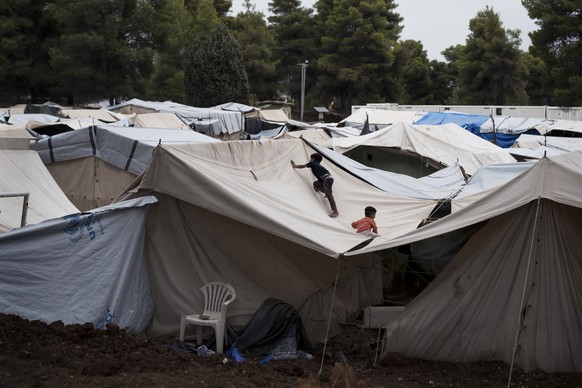 In this Thursday, Sept. 8, 2016 photo, Syrian children play on the top of a tent at the Ritsona camp for refugees and other migrants north of Athens. Like dozens of refugee camps hastily created around Greece, Ritsona started with tents set up in an abandoned military facility. (AP Photo/Petros Giannakouris) 