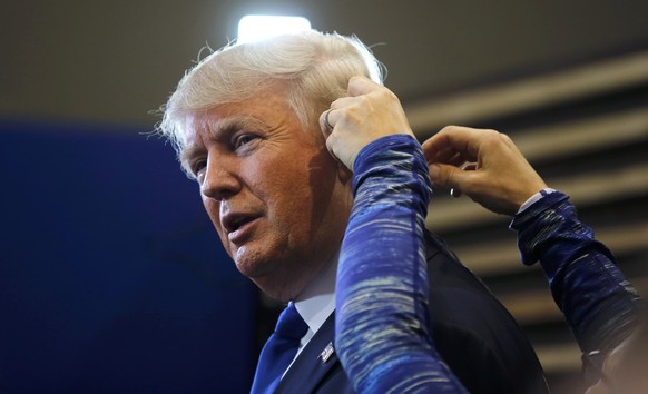 Republican U.S. presidential candidate businessman Donald Trump has ian earpiece put in before a TV interview in the spin room after the Republican U.S. presidential candidates debate sponsored by ABC ...