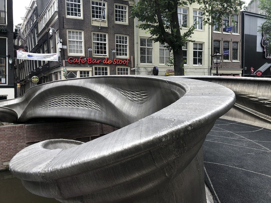 A steel 3D-printed pedestrian bridge spans a canal in the heart of the red light district in Amsterdam, Netherlands, Thursday, July 15, 2021. The distinctive flowing lines of the 12-meter (40-foot) br ...