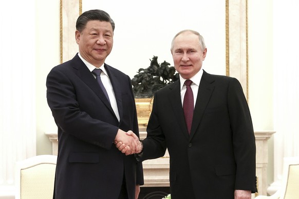 In this handout photo released by Russian Presidential Press Office, Russian President Vladimir Putin, right, and Chinese President Xi Jinping shake hands prior to their talks at the Kremlin in Moscow ...