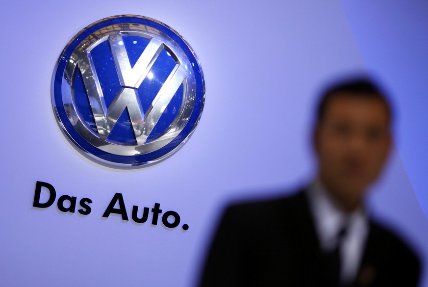 A security guard stand next to a Volkswagen logo at the stage of the company prior to the opening of the 15th Shanghai International Automobile Industry Exhibition in this April 19, 2013 file photogra ...