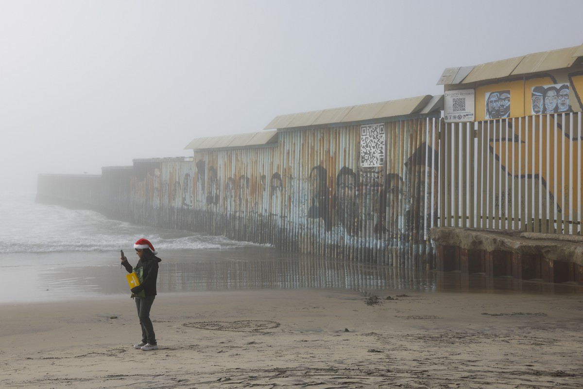 epaselect epa11784753 A person walks along the beach by the US-Mexico border wall in Tijuana, Mexico, 18 December 2024. On 17 December 2024, US President Joe Biden announced stricter asylum rules that ...