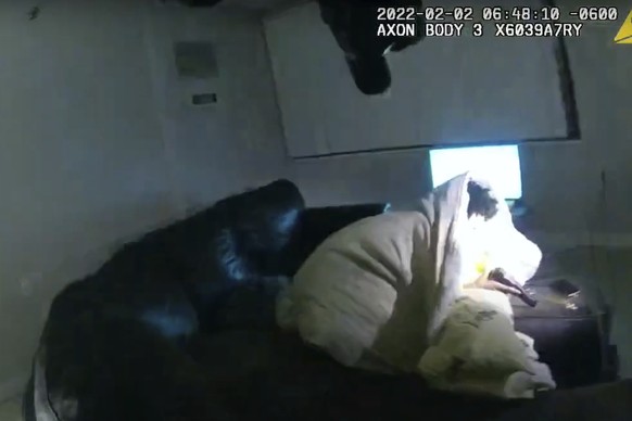 In this image taken from Minneapolis Police Department body camera video and released by the city of Minneapolis, 22-year-old Amir Locke wrapped in a blanket on a couch holding a gun moments before he ...