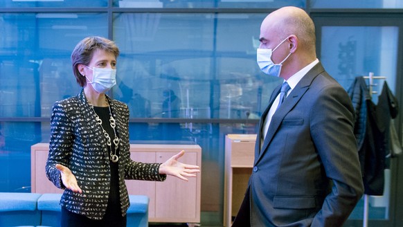 Bundesrat Alain Berset, Bundespraesidentin Simonetta Sommaruga, links, besprechen sich am Rande einer ausserordentlichen Medienkonferenz zu den verschaerften Corona-Massnahmen, am Sonntag, 18. Oktober ...