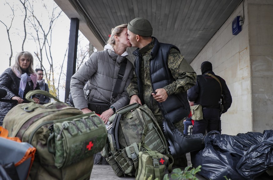 epa10238572 Russian conscripted man says goodbye to relative at a recruiting office during Russia's partial military mobilization in Moscow, Russia, 12 October 2022. Russian President Putin announced  ...