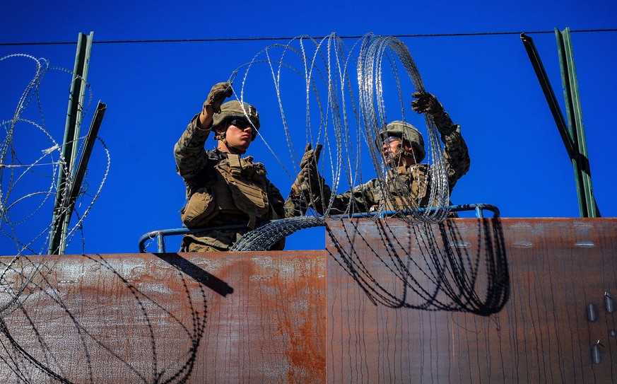 epa07161704 US military soldiers install barbed wire on the border with Mexico as seen from Colonia Libertad in Tijuana, Mexico, 12 November 2018. Around 4,000 migrants departed in the morning from Ir ...