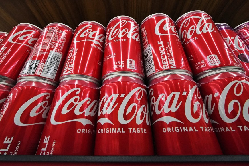 Cans of Coca-Cola are on display at a grocery market in Uniontown, Pa, on Sunday, April 24, 2022. (AP Photo/Gene J. Puskar)