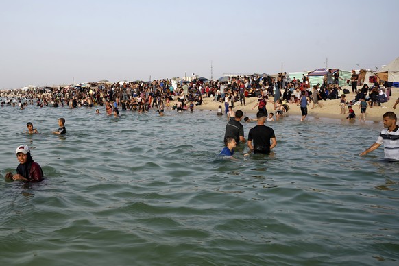 Palestinians who have been displaced by the ongoing war with Israel, enjoy the water of the Mediterranean Sea during a heat wave at Khan Younis beach, southern Gaza Strip, Monday, May 20, 2024. (AP Ph ...