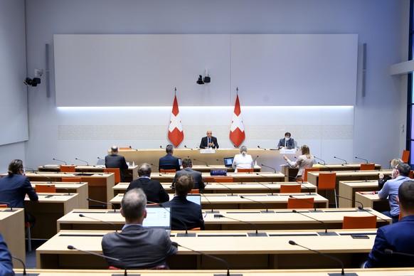 Bundesrat Alain Berset, Mitte, spricht an der Seite von Vizekanzler Andre Simonazzi, Bundesratssprecher, rechts, an einer Medienkonferenz ueber die neusten Entscheide des Bundesrates zur Coronavirus-P ...
