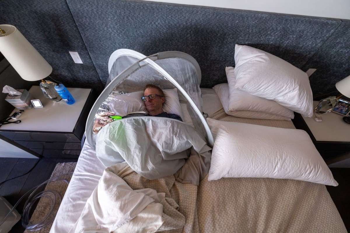 Truckee, CA - April 18: Graham Cooper relaxes with a book after a morning train session inside a bevy tent hooked up to an altitude generator where he breathes oxygen reduced air to prepare for an asc ...