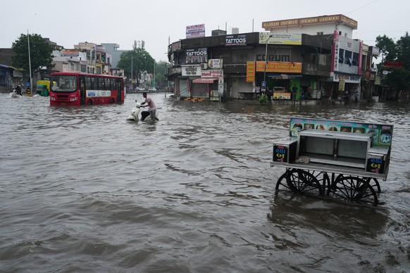 A man pushes his stalled two wheeler through a water-logged road during monsoon rain in Ahmedabad, India, Friday, July 24, 2026. (AP Photo/Ajit Solanki)
India Extreme Weather Monsoon