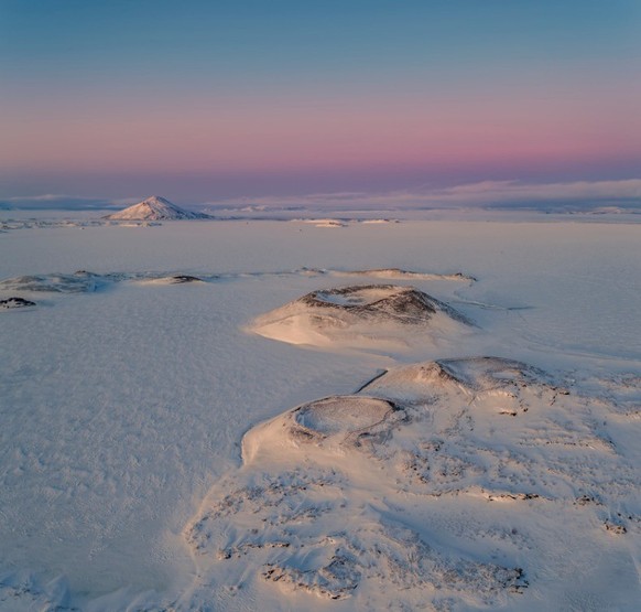 Pseudokrater am zugefrorenen See Mývatn erinnern an eine Mondlandschaft.