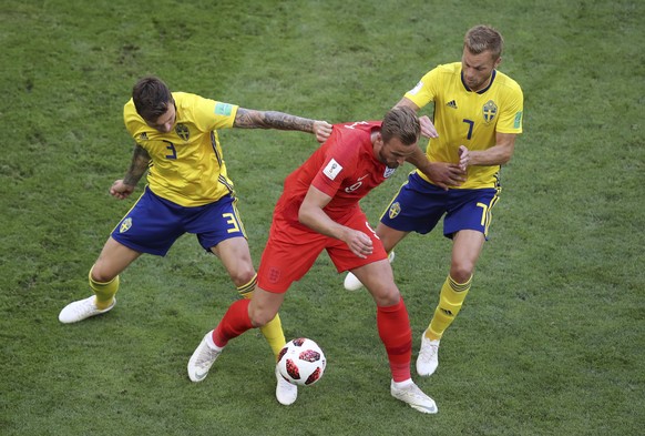 England&#039;s Harry Kane fights for the ball with Sweden&#039;s Victor Lindelof and Sebastian Larsson, right, during the quarterfinal match between Sweden and England at the 2018 soccer World Cup in  ...