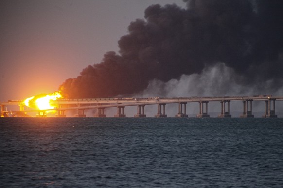 FILE - Flame and smoke rise fron Crimean Bridge connecting Russian mainland and Crimean peninsula over the Kerch Strait, in Kerch, Crimea, Saturday, Oct. 8, 2022. The Crimean Peninsula&#039;s balmy be ...