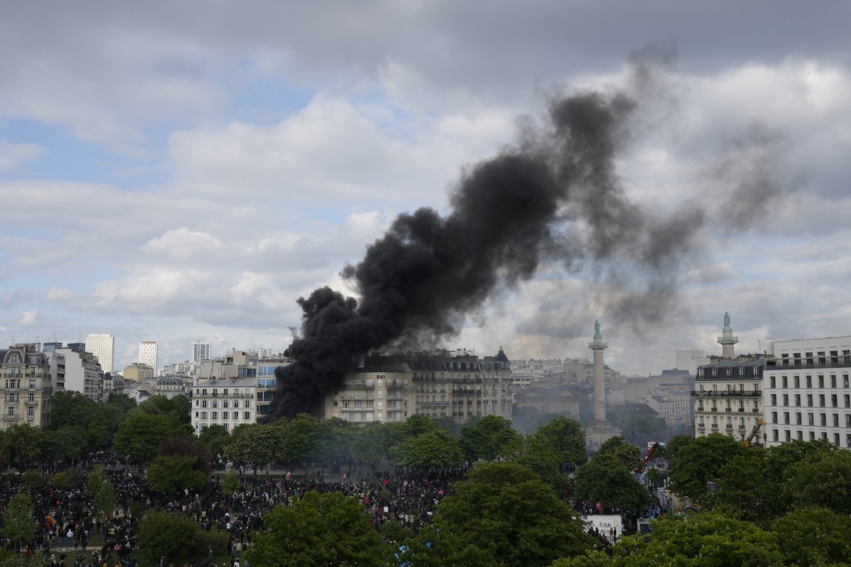 Smoke billows on Place de la Nation after youths set a fire during a demonstration, Monday, May 1, 2023 in Paris. Across France, thousands marched in what unions hope are the country's biggest Ma ...