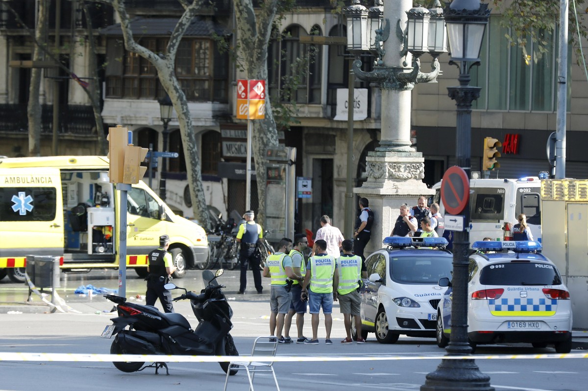 epa06148694 Mossos d'Esquadra Police officers and emergency service workers set up a security perimeter near the site where a van crashes into pedestrians in Las Ramblas, downtown Barcelona, Spai ...
